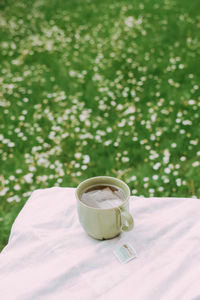 High angle view of tea cup on table against grassy field