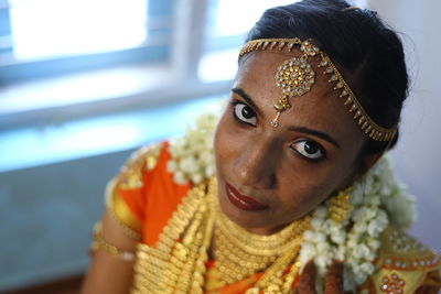 Close-up portrait of bride sitting at home