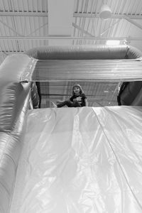 Low angle view portrait of girl sitting on bouncy castle