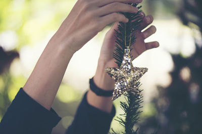 Close-up of hand holding star shape christmas ornament
