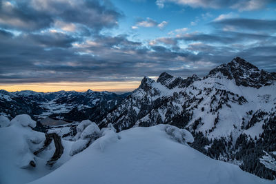 Scenic view of snow covered mountains against sky during sunset