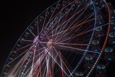 Low angle view of illuminated ferris wheel against sky at night