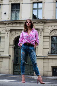 Portrait of a woman standing against a building in a city