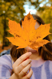 Cropped hand holding autumn leaf