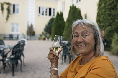 Smiling woman holding glass of wine