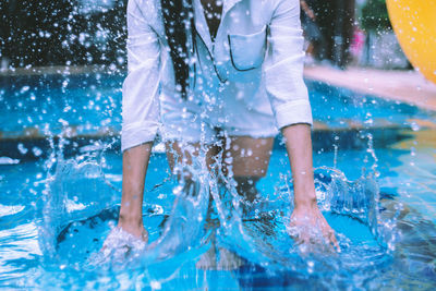 Man splashing water in swimming pool