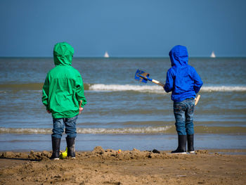 Two boys from behind looking towards the open sea at bray-dunes, france