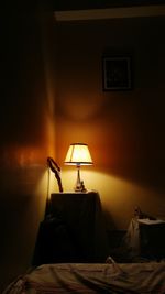Illuminated lamp in darkroom at home