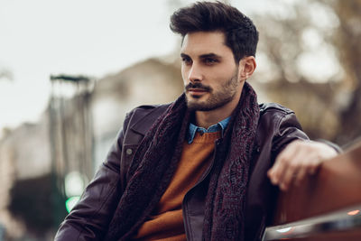 Young man sitting on bench in park