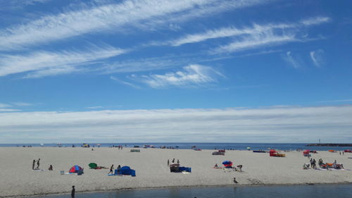 People at beach against sky