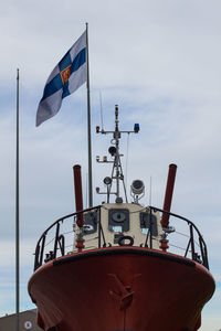 Close-up of flag sailing on sea against sky