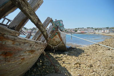 Abandoned boat on beach against clear sky