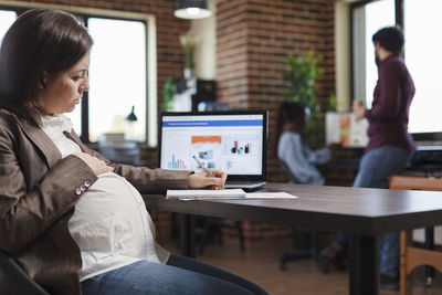 Pregnant businesswoman working at office