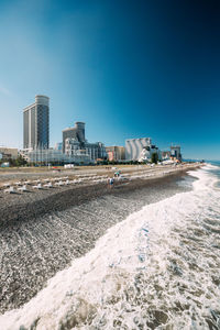 View of buildings at beach against blue sky