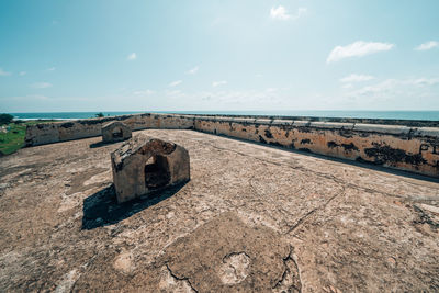 Old ruins by sea against sky