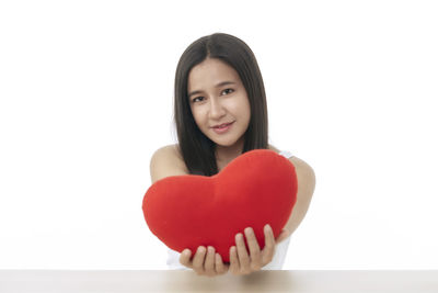 Portrait of a smiling young woman against white background