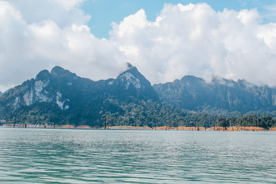 Scenic view of lake by mountains against sky