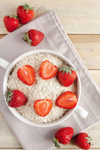 Oat muesli and fresh strawberries on wooden background. healthy breakfast food. bowl of oatmeal 