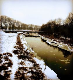 Scenic view of lake against sky during winter