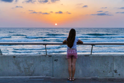 Rear view of woman standing on beach