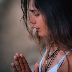 Side view of woman doing yoga while sitting on pier at lake