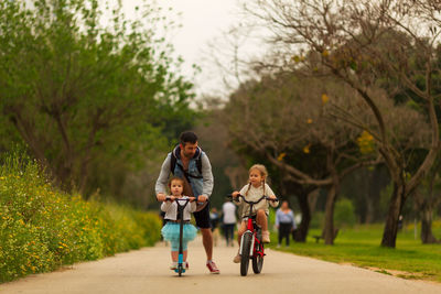 Rear view of people riding bicycle on plants