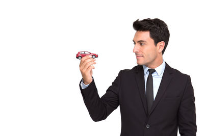 Mid adult man holding umbrella against white background