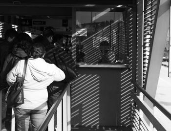 Rear view of people standing on staircase