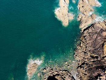 High angle view of rocks by sea at beach