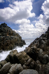 Rocks by sea against sky