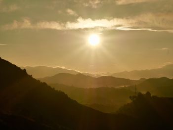 Scenic view of silhouette mountains against sky at sunset