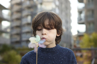 Boy blowing on pinwheel outdoors