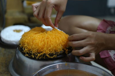 Cropped hands of woman preparing food at home