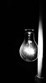 Close-up of light bulb against black background