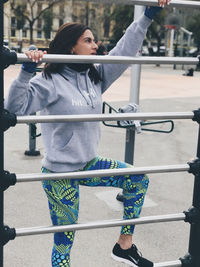 Young woman sitting on railing