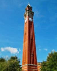 Low angle view of clock tower against blue sky