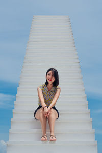 Portrait of smiling young woman against sky