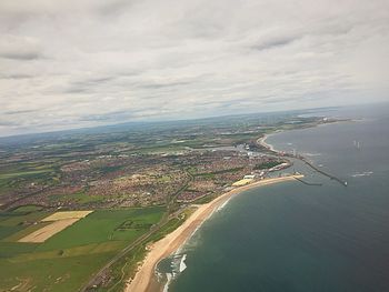 Aerial view of cityscape against cloudy sky