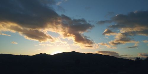 Scenic view of silhouette mountains against sky during sunset