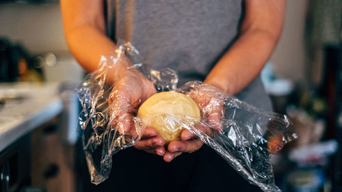 Midsection of woman holding dough