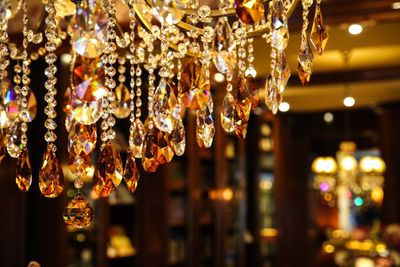 Close-up of illuminated light bulb hanging at night