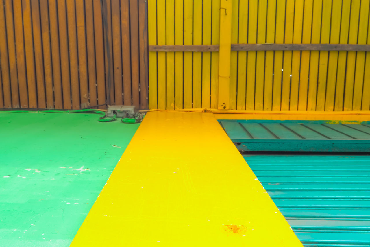 HIGH ANGLE VIEW OF YELLOW WALL BY SWIMMING POOL AT PLAYGROUND