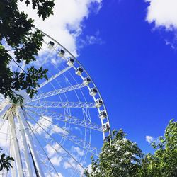 Low angle view of ferris wheel against blue sky