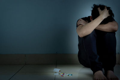 Man playing piano against wall at home