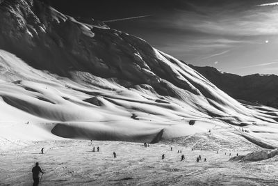 A black and white of skiers making their way down the slopes in les arcs