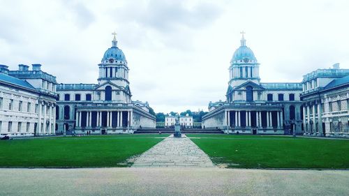 Facade of historical building against cloudy sky