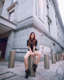 Portrait of woman sitting outside building