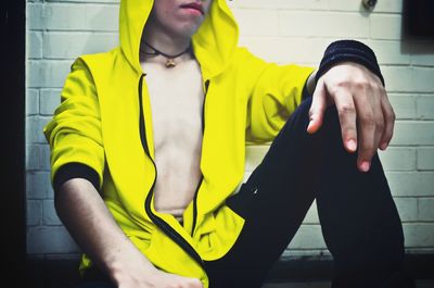 Midsection of man standing with yellow umbrella