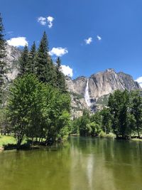 Scenic view of lake by trees against sky