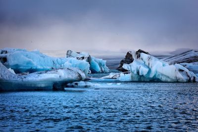 Scenic view of frozen sea against sky at sunset